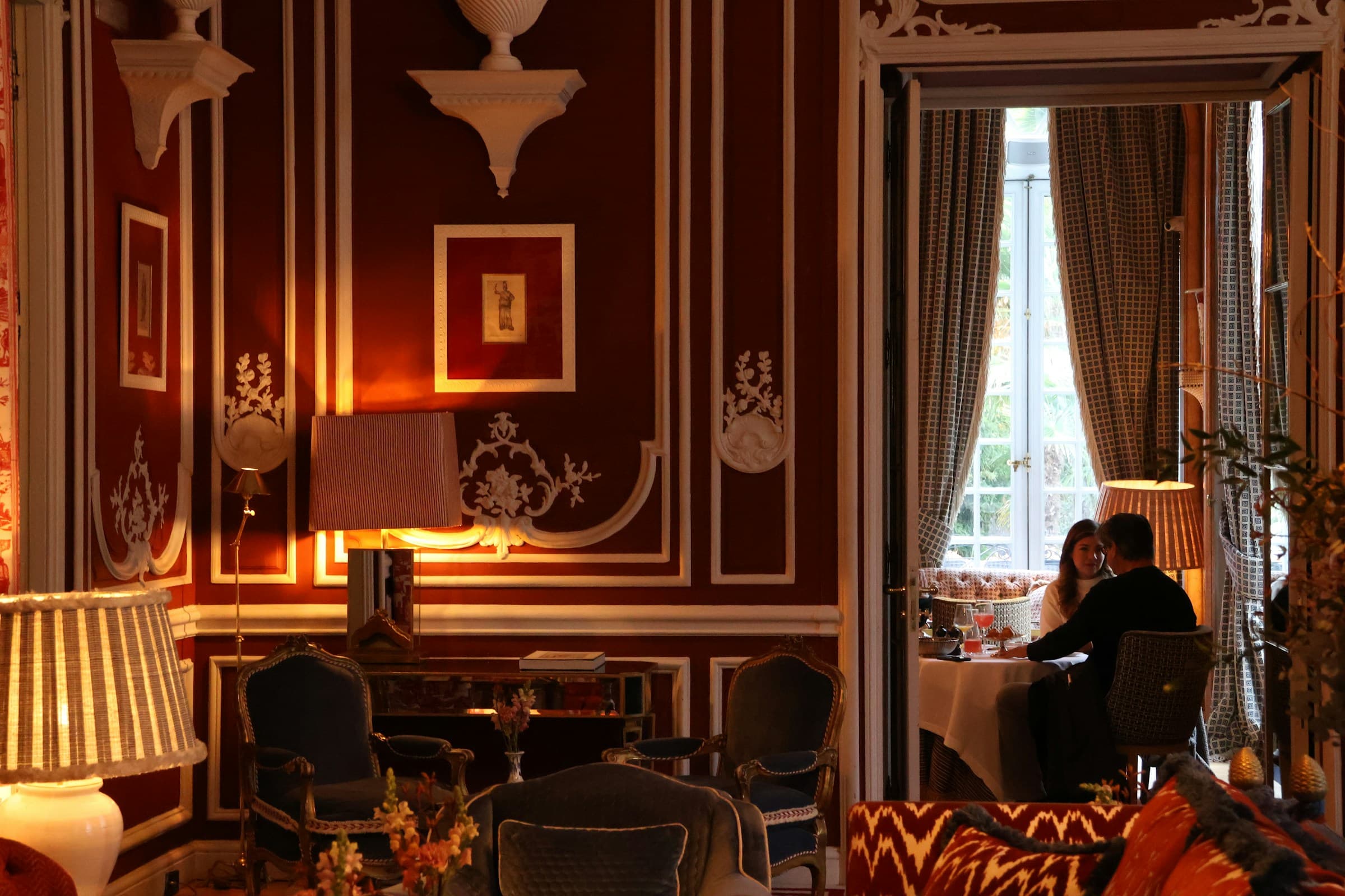 Salon hôtelier avec cheminée — confort, matières, lumière dorée.